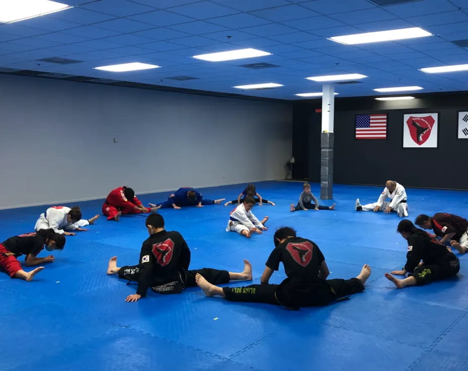 a group of people sitting on a mat in a room