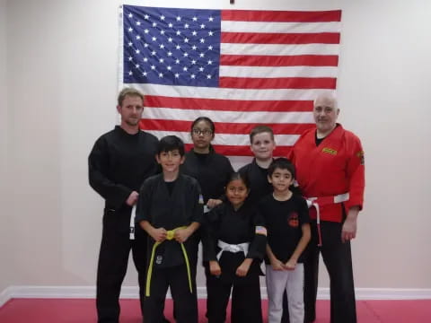 a group of people posing for a photo in front of a flag