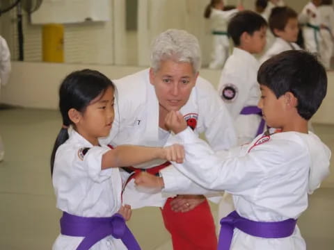 a person and a few children in karate uniforms