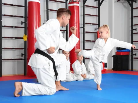 a man and a boy in karate uniforms in a room with red bars