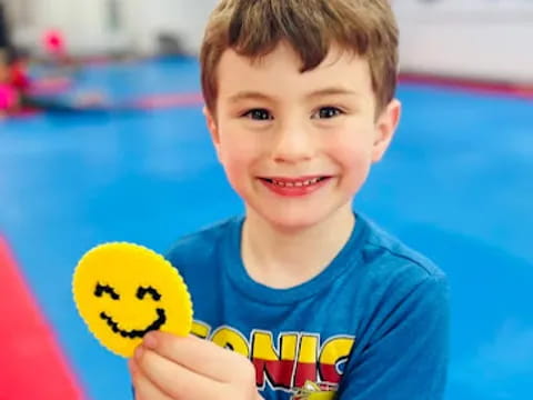 a boy holding a yellow toy