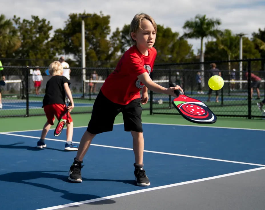 a boy hitting a ball with a racket