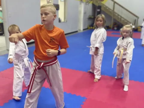 a group of children in karate uniforms