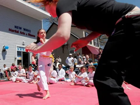 a man and woman in a martial arts ring with a crowd watching