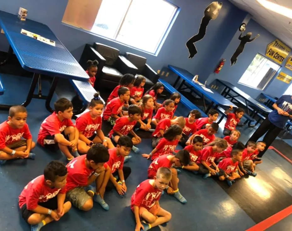 a group of children sitting on the floor in a room