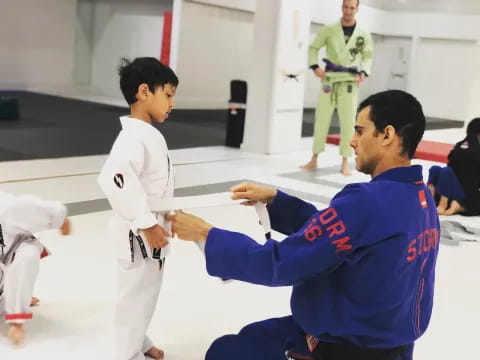 a person shaking hands with another man in a karate uniform