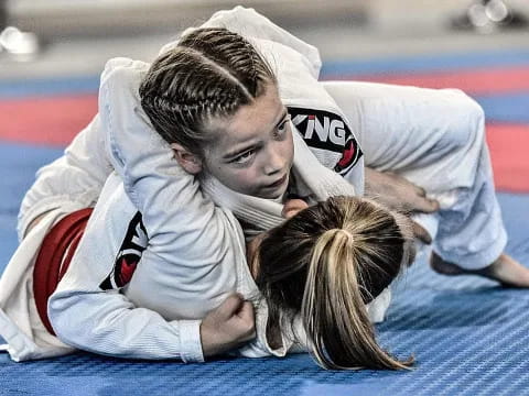 a man and a woman in karate uniforms on the ground