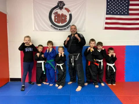 a person standing with a group of kids in karate uniforms