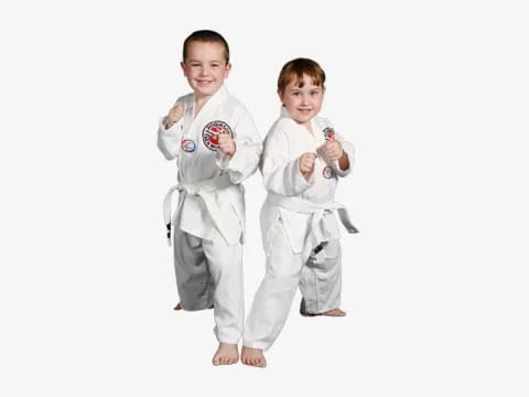a couple of boys in white karate uniforms