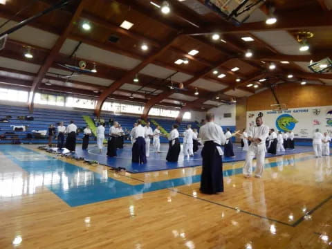 a group of people in white karate uniforms on a wooden floor