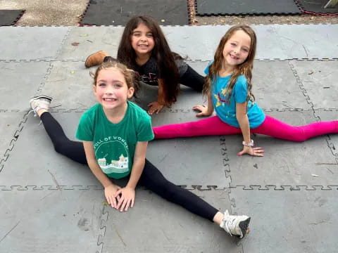 a group of kids sitting on a sidewalk