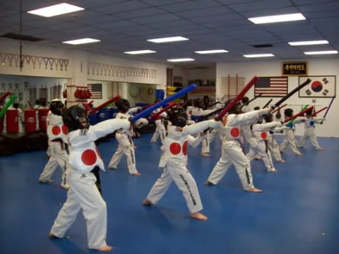 a group of people in white karate uniforms holding swords