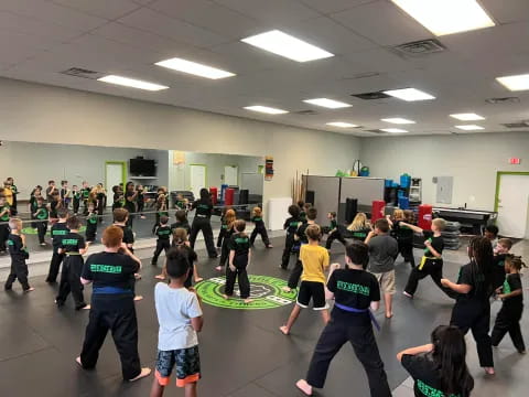 a group of people dancing in a room with a green wall and white walls