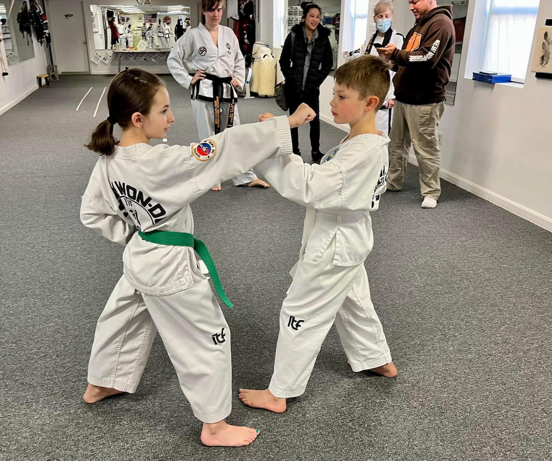 a couple of children in karate uniforms