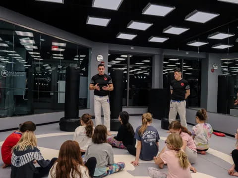 a group of people sitting in a room with a person standing in front of a group of people