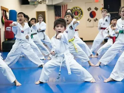 a group of children in white karate uniforms