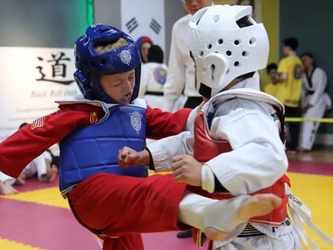 a person kneeling next to a boy in a helmet and a red and white uniform