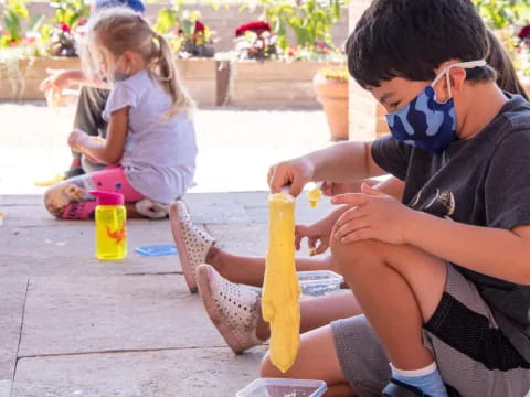 a group of children sitting on the ground with a toy