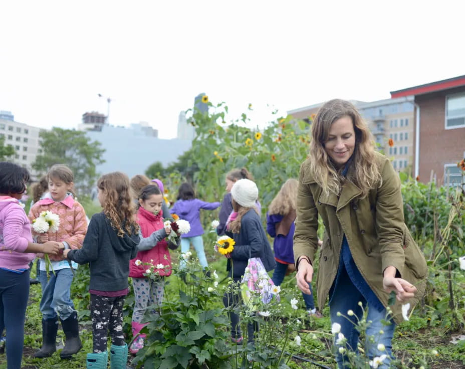 a person and a group of children in a garden