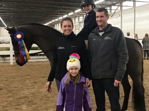 a group of people posing for a photo with a horse