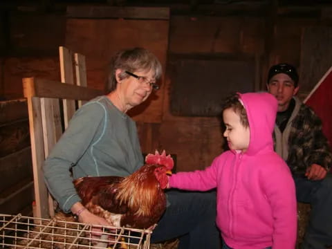 a person and a couple of children with a chicken