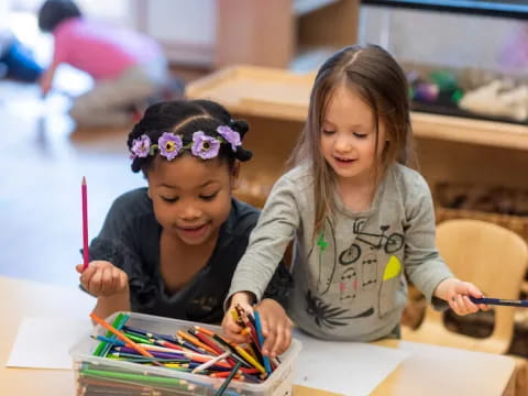 a few children coloring on paper