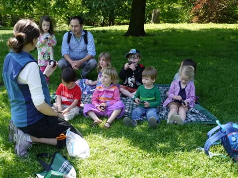 a group of people sitting on the grass