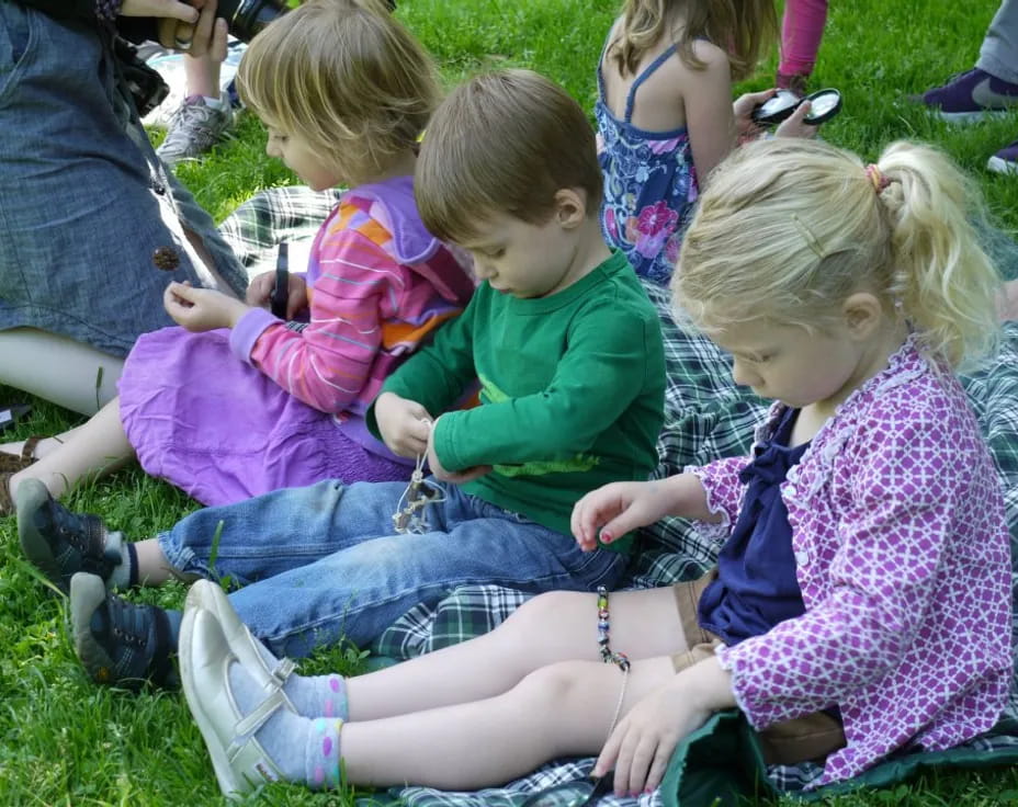 a group of children sitting on the grass