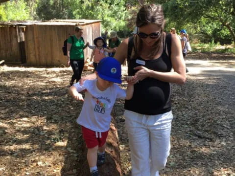 a person and a child walking on a dirt path