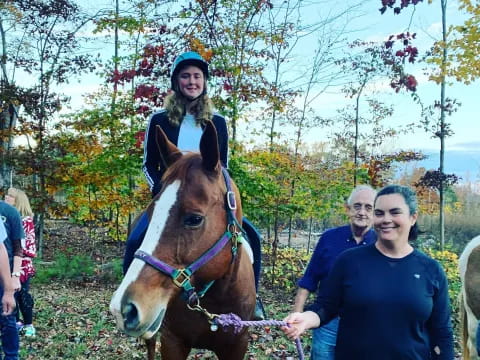 a woman riding a horse with a man on the back