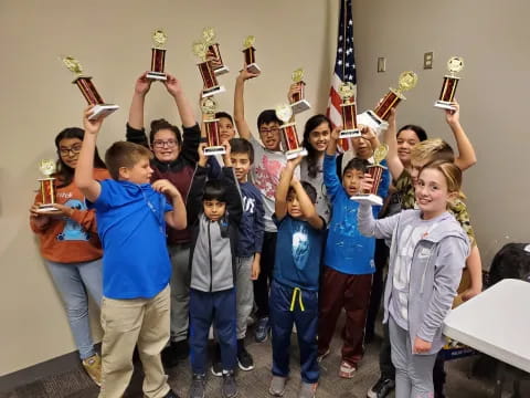 a group of children holding trophies