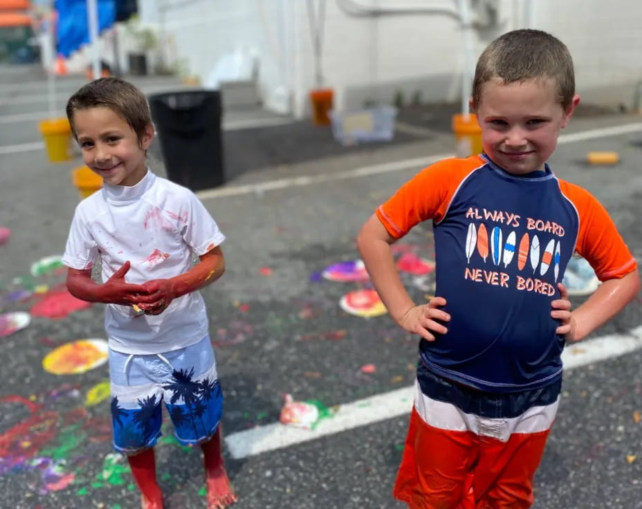 two boys running in a puddle