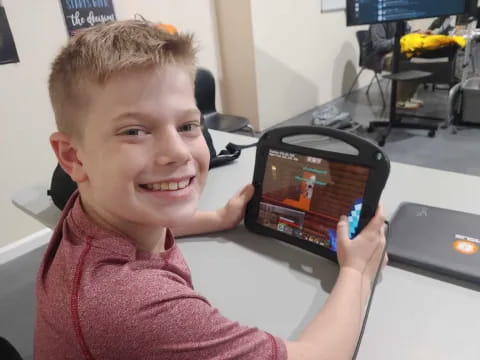 a boy holding a tablet