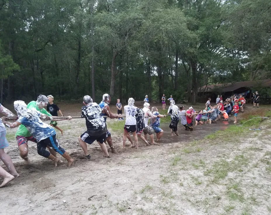 a group of people running in a mud field
