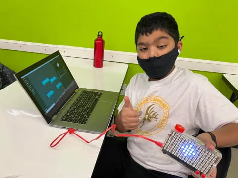 a person wearing a mask and holding a laptop