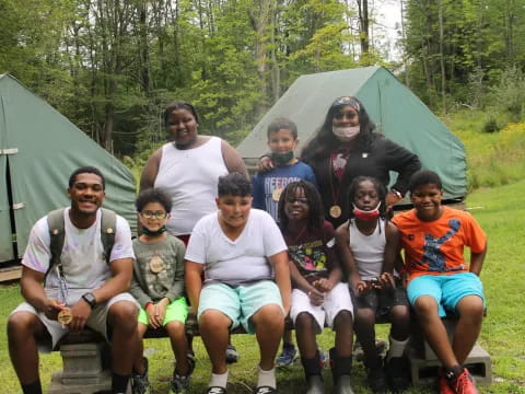 a group of people posing for a photo in front of a tent