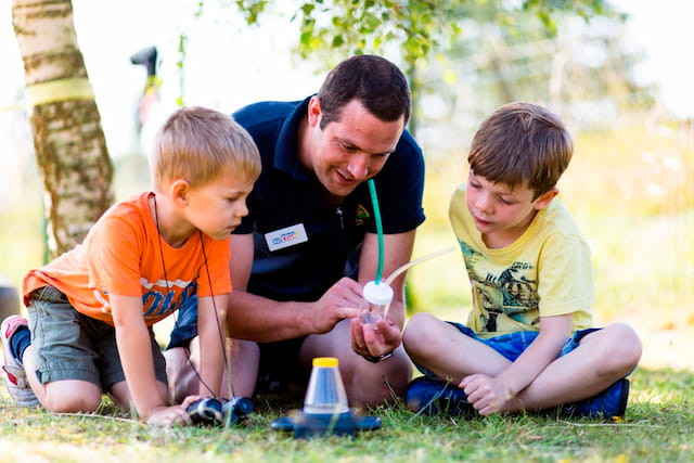 a person and two boys playing with a toy