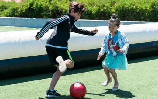 a boy kicking a football ball