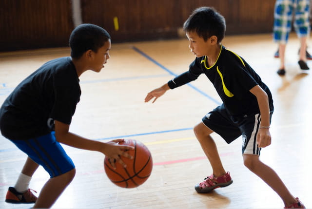 a couple of boys playing basketball