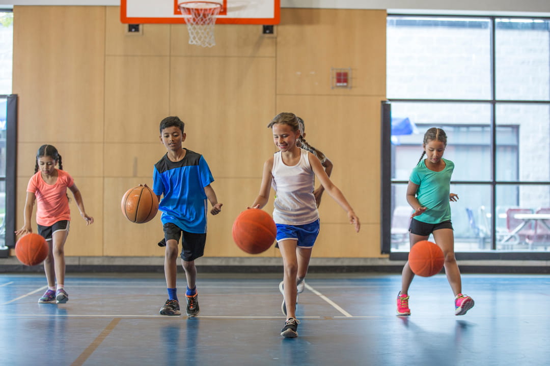 a group of kids playing basketball