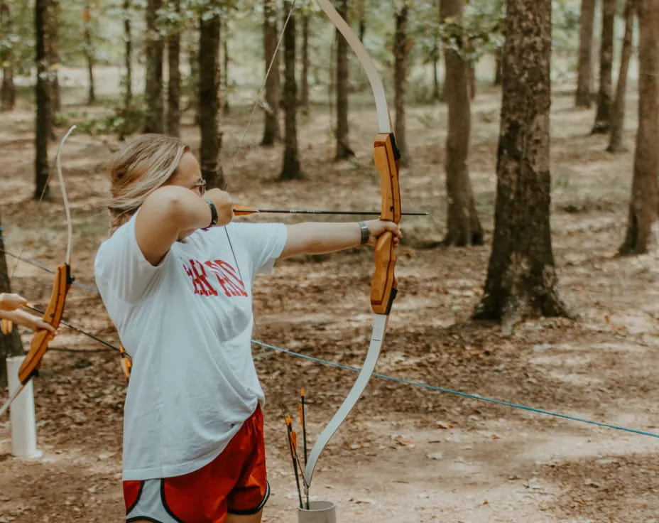 a man shooting bows in the woods