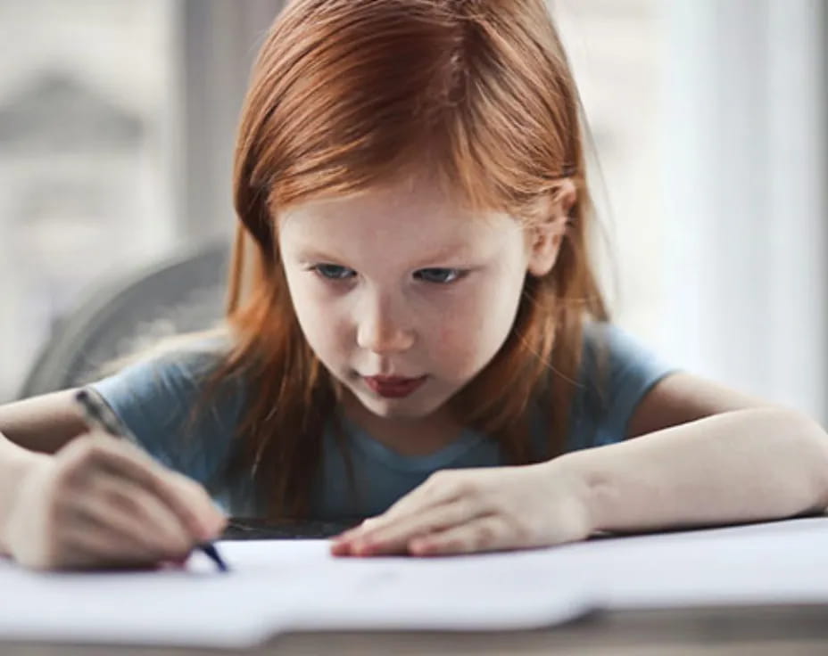 a young girl looking at a book