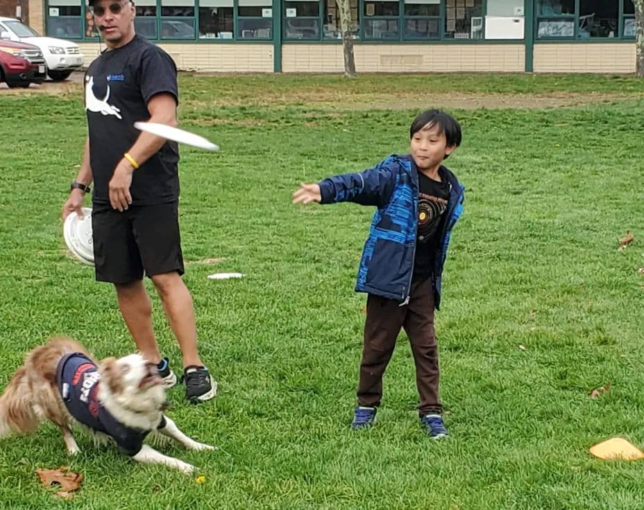 a person and a boy playing with a dog