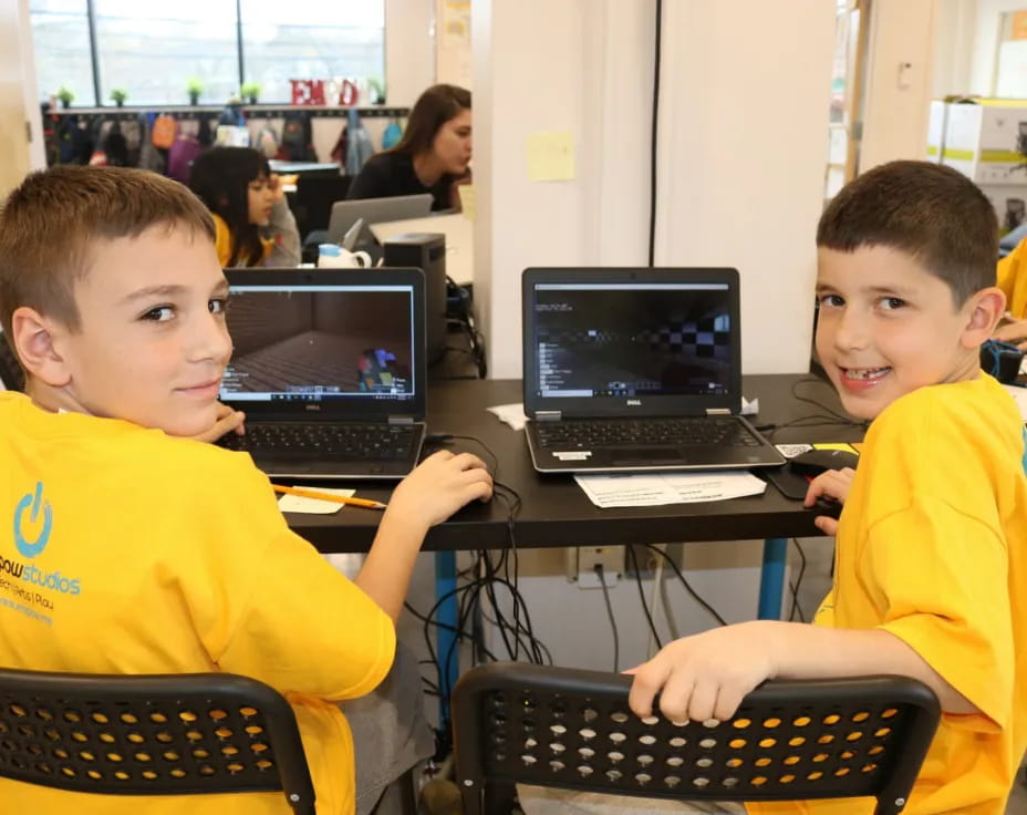a few young boys using laptops
