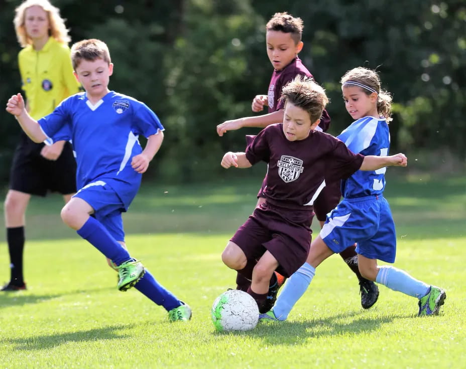 kids chasing a football ball