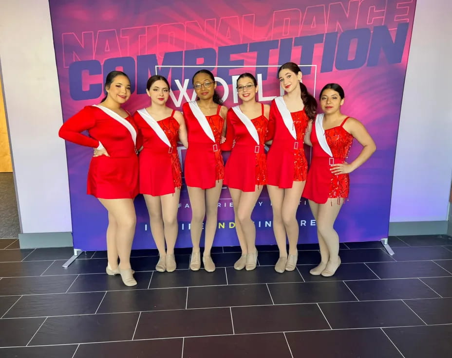 a group of women in red dresses