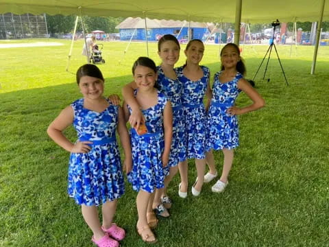 a group of girls in blue dresses