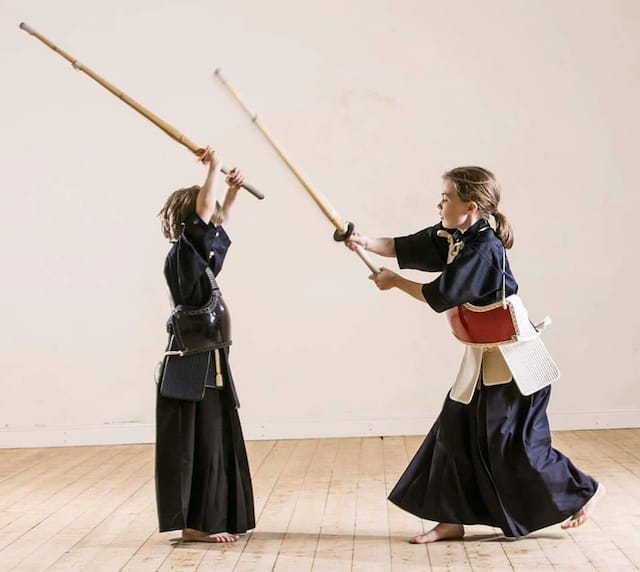 a couple of women in black robes holding swords