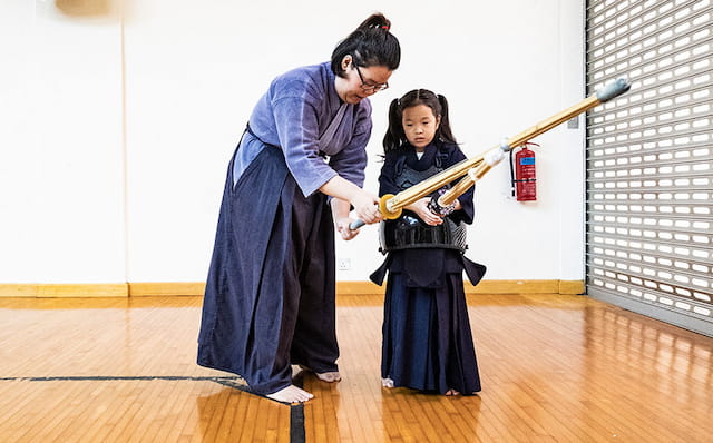 a man and a woman holding a sword and a can