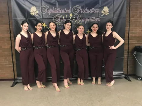 a group of women in black dresses